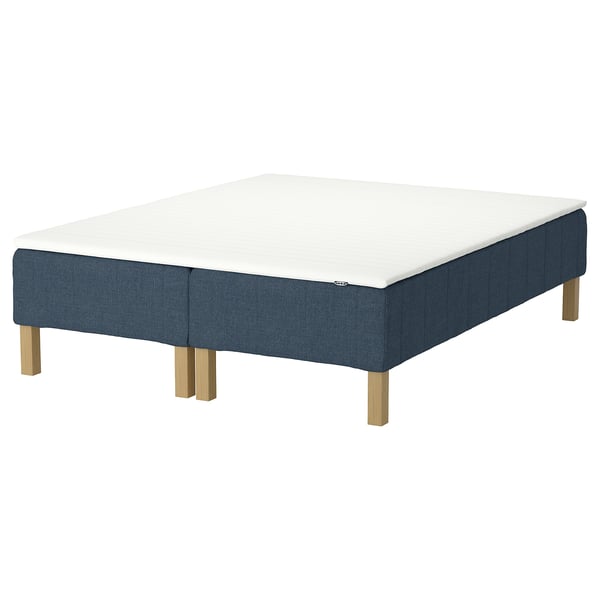 Square mattress on blue base, wood legs; soft, supportive, motion isolating.