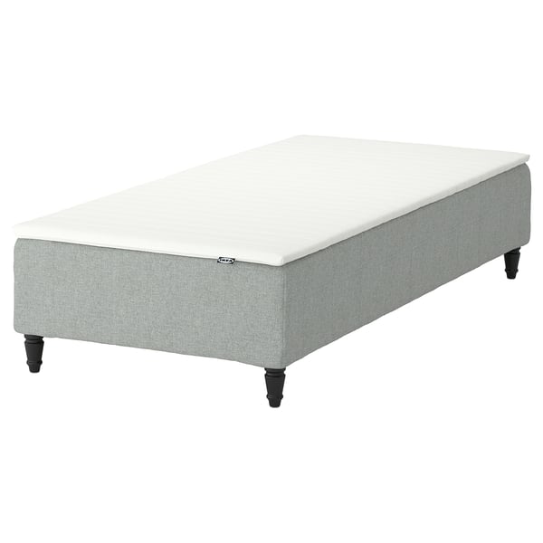 Light grey IKEA RENFJÄLLET bed with white topper, rectangular, upholstered.