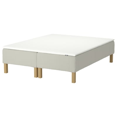 The IKEA RENFJÄLLET mattress base is white with light wood legs. It pocket springs for motion isolation and a removable, washable cover.