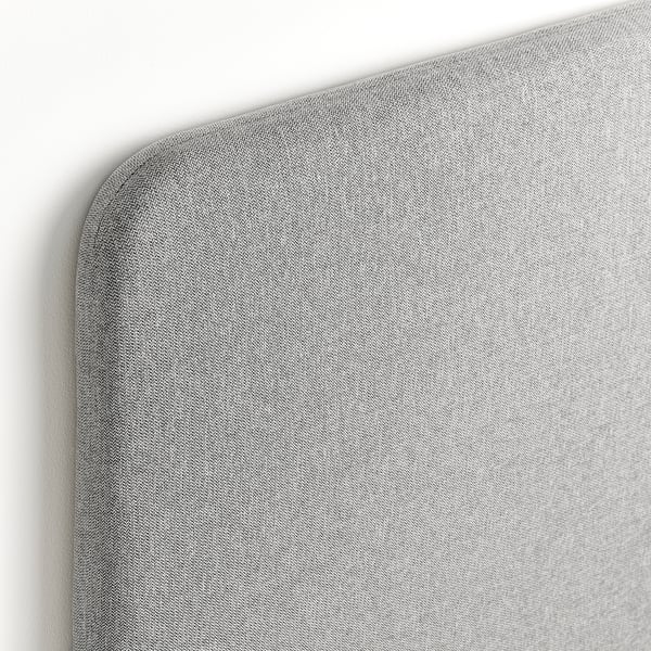 Close-up of a grey upholstered headboard, showcasing its smooth, curved edge and textured fabric quality.