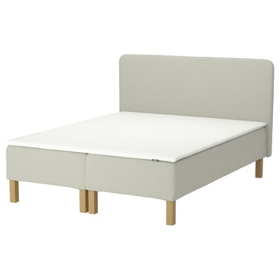 The renfjjället bed a white mattress and off-white headboard with wooden legs.