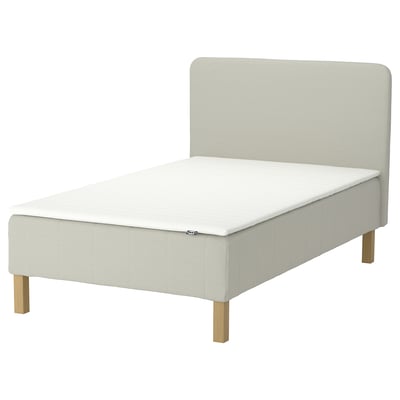 A RENFJÄLLET bed in beige with wooden legs and a matching headboard. It pocket springs for motion isolation.