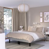 Modern bedroom with RENFJÄLLET bed, light grey, geometric bedding, circular lamp, large windows.