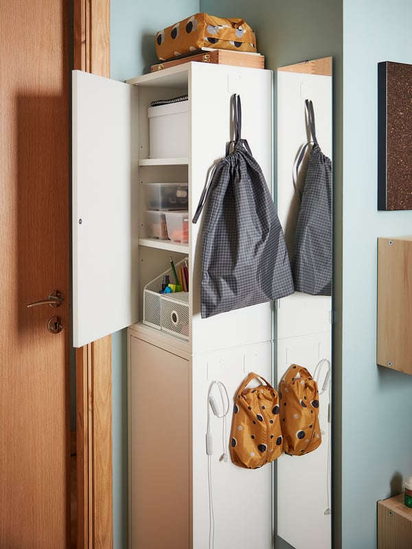 White cabinet with shelves, storage boxes, gray & orange RENSARE bags, blue wall.