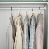 Clothes covers in closet protect garments from dust. Hang delicate items neatly.