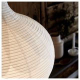 A risbyon lamp with light birch veneer and rice paper shade. The lamp has a cylindrical base and a rounded shade, creating a soft, warm light.