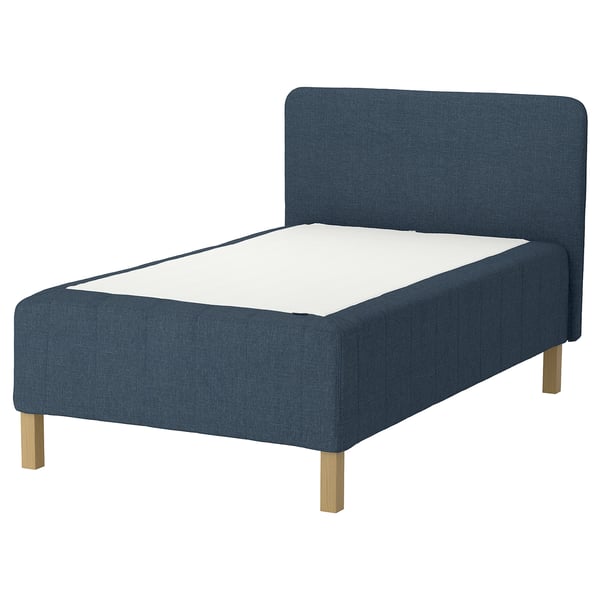 Blue fabric upholstered bed with wooden legs and white mattress.