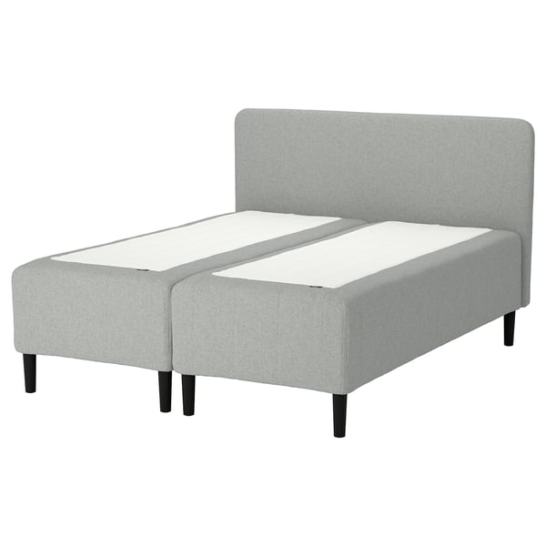 The rishojden bed is a modern, light grey fabric design with a high headboard and dark wooden legs, featuring adjustable comfort zones.