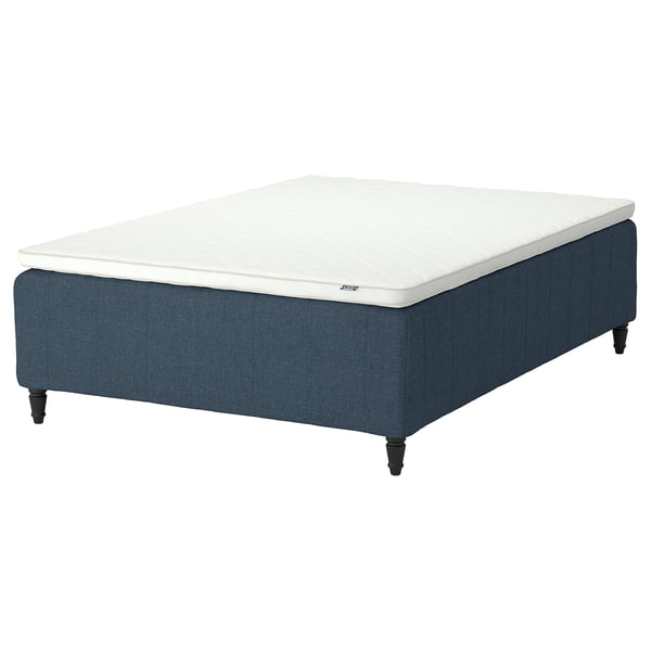 Blue upholstered bed base with white mattress, four wooden legs, modern design.