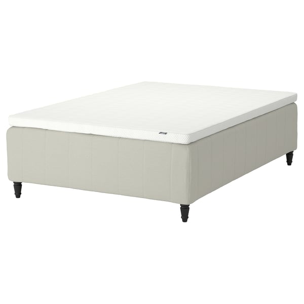 A white RISHÖJDEN mattress on a base with wooden legs.
