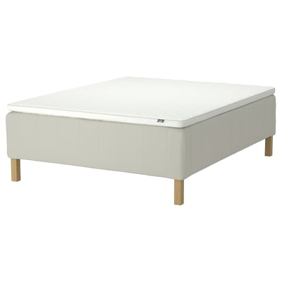 Flat, white square bed on legs, soft fabric cover, firm edges, modern design.