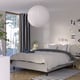 Modern bedroom RISHÖJDEN bed with spotted bedding, white pendant light, striped rug, and sleek furniture.