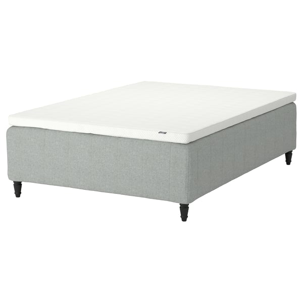 A RISHÖJDEN bed base with a white mattress, featuring upholstered light grey fabric and black wooden legs.