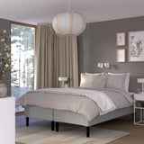 Modern grey bedroom with RISHÖJDEN bed, hanging light, grey curtains, art, and rug.