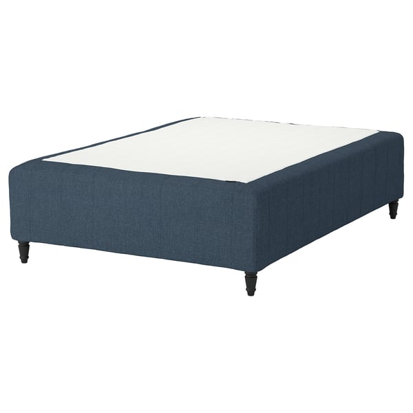 A blue fabric RISHÖJDEN bed base with wooden legs and a white mattress on top.