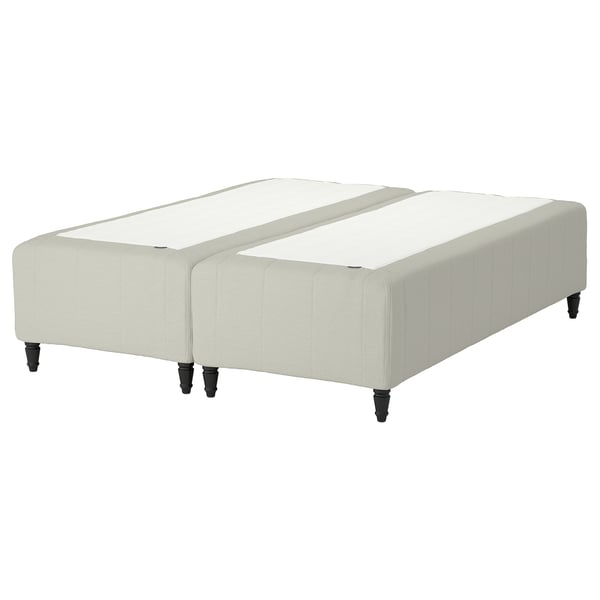 RISHÖJDEN bed base, beige, upholstered with wood legs, divided into two sections.