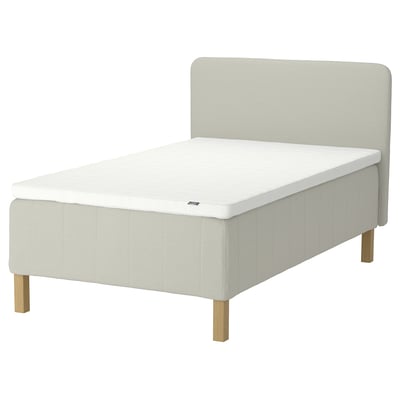 Off-white RISHÖJDEN bed with plush headboard, wooden legs, and upholstered fabric.