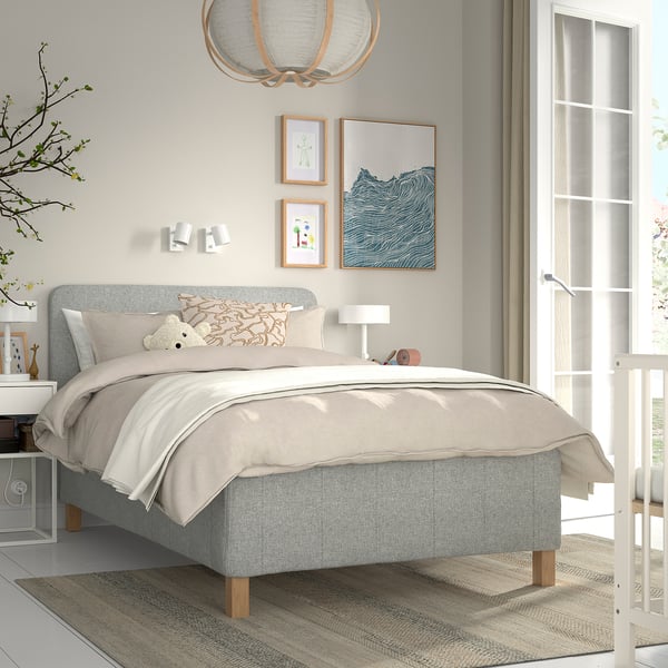 Modern bedroom with grey RISHÖJDEN bed, soft headboard, white decor, and natural light.