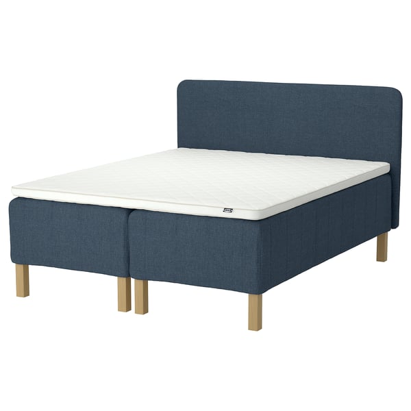 Blue bed with white mattress, wooden legs, padded headboard.