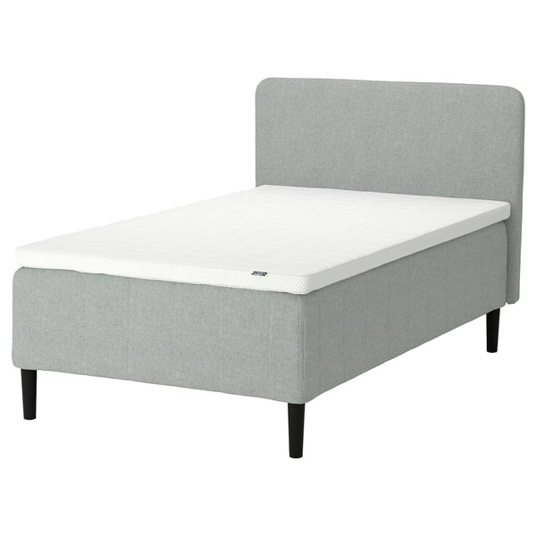 A RISHÖJDEN bed in light grey with a white mattress, featuring a curved headboard and black wooden legs, designed for comfort and easy assembly.