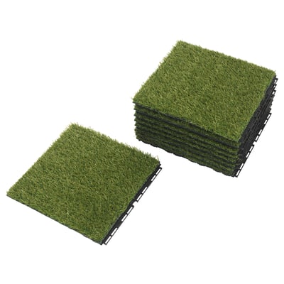 Two stacks of green artificial grass tiles, interlocked, for outdoor use.