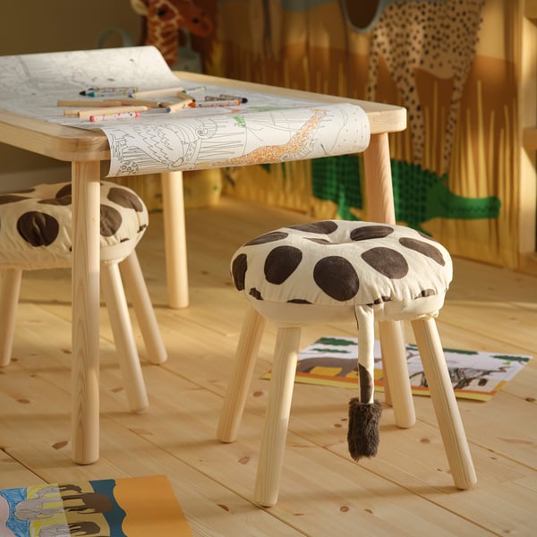Childs room with giraffe stools, coloring table, toys; playful & inviting.