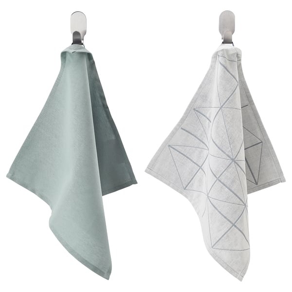 Two light-colored towels hang on hooks, one plain and one with a geometric pattern.