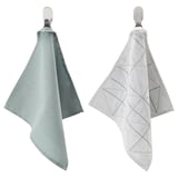 Two light-colored towels hang on hooks, one plain and one with a geometric pattern.