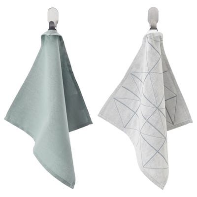 Two light-colored towels hang on hooks, one plain and one with a geometric pattern.