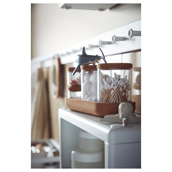 SAXBORGA glass jars with cork lids holding cotton swabs on a shelf. White, round, with decorative shark and elephant lids.