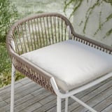 The SEGERÖN outdoor chair is brown and white wicker with a beige cushion, perfect for balconies or patios.