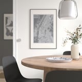 Minimalist dining setup with SILVERSIDA table, black/white plate, dried flowers, map decor.