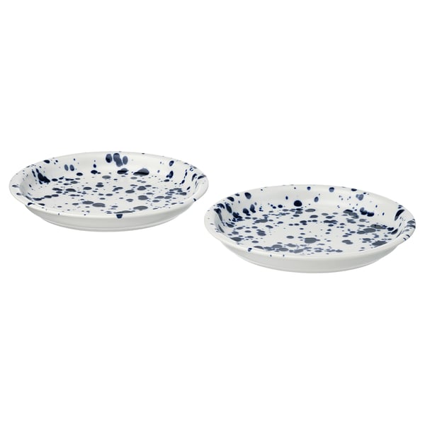 Two white, shallow dishes with blue splatter pattern, made of stoneware with glazed finish. Round shape, edges slightly raised.