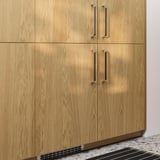 Four light wooden cabinets with silver handles.