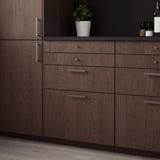 Dark wood SINARP cabinet with sleek handles, featuring solid oak edges. Size: large, fits against tall units.