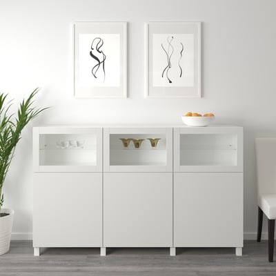 White SINDVIK cabinet with glass doors displays decor, controlling electronics through glass.