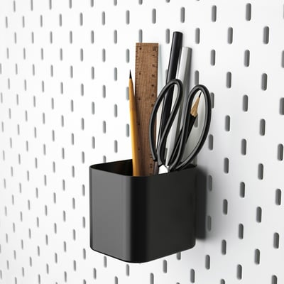 Black SKÅDIS cup on white board with office supplies.