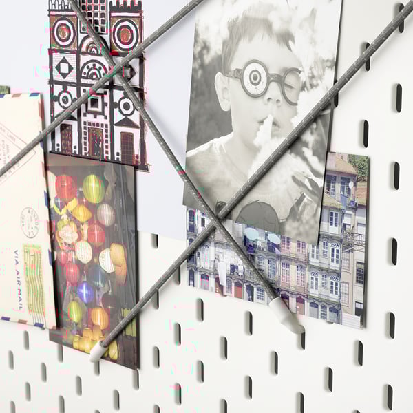 SKÅDIS pegboard with accessories holding photos and decor.