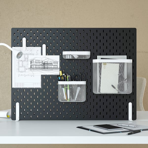 Gray SKÅDIS pegboard, wall-mounted, holding lamp, drawings, office supplies.