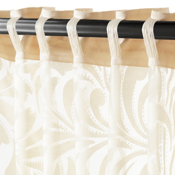 Sheer curtains with floral patterns on rod, allowing light while ensuring privacy.