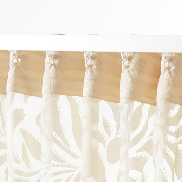Sheer curtains with a floral pattern. They filter light and offer privacy, ideal for layered window solutions. The top hooks for easy hanging.