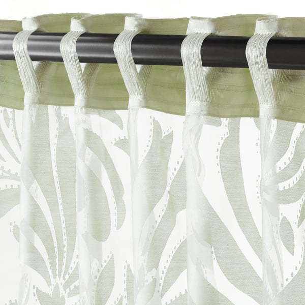 Sheer green-white curtains hang, allowing light through, with visible rod and hanging tabs.