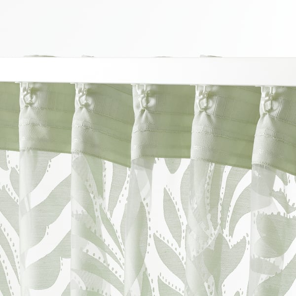 Sheer green floral curtains hanging, displaying privacy with light flow.