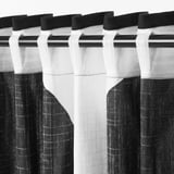 Black and white striped curtains hanging, blocking view while letting filtered light in.