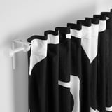 Black and white patterned curtains with white rod and bracket, providing privacy and light filtering.
