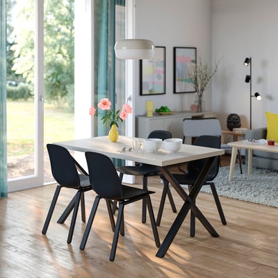 Modern dining set: SKÅLSTA white table, black chairs. Square table, angular legs. Big window, bright room.