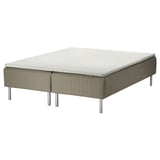 An IKEA skärer bed with a beige, quilted fabric base, a white mattress, and four silver legs.
