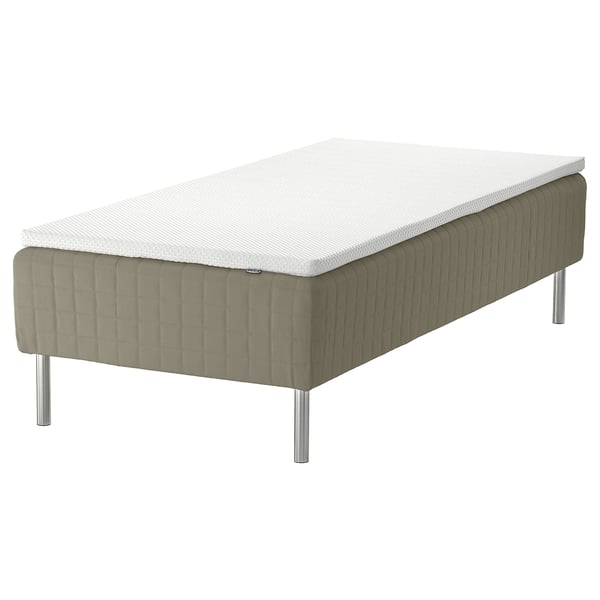 SKÅRER bed in beige with white mattress. Modern design, sprung base, four stainless steel legs.