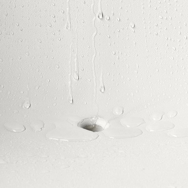 Water droplets drain from SKARPÖ armchairs seat hole, showcasing its self-draining feature.