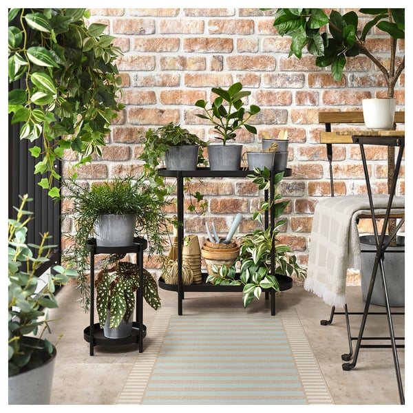 Striped SKEVNING outdoor rug with plants, creating cozy indoor/outdoor space.